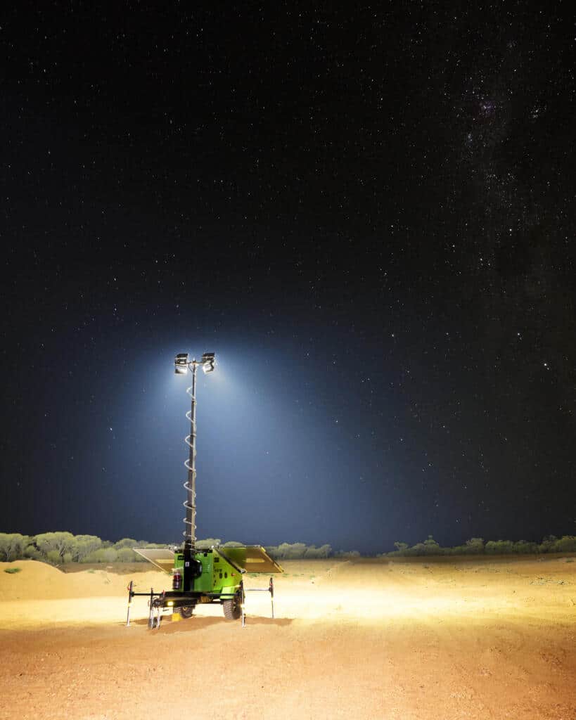 A EcoQuip solar light tower in the desert under a starry sky.